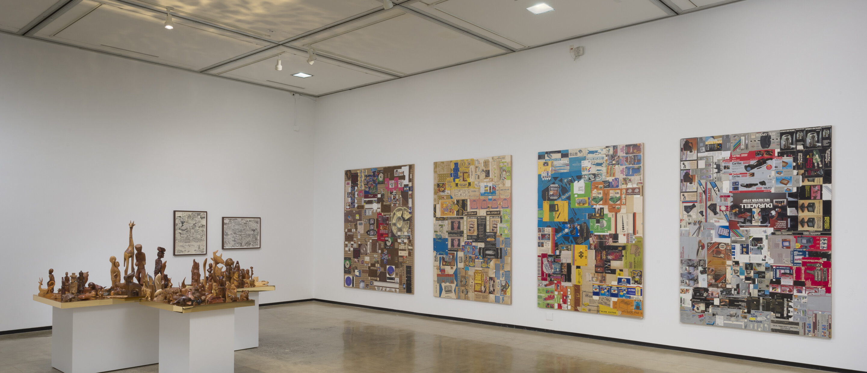 Installation view of R.S.V.P. Los Angeles with 4 multi-media works on the wall and table with multiple wooden sculptures
