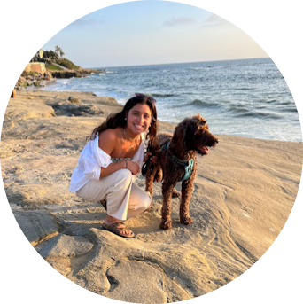 Student next to a dog on the beach