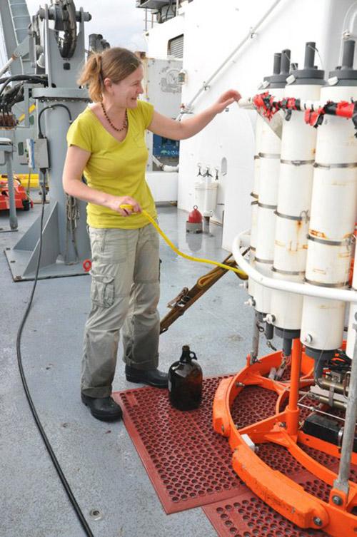 Masha Prokopenko stands aboard a ship with research tubes