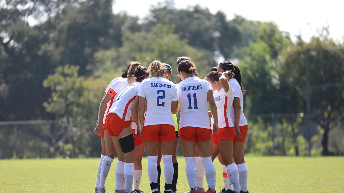 Pomona-Pitzer's women's soccer team huddles during a game.