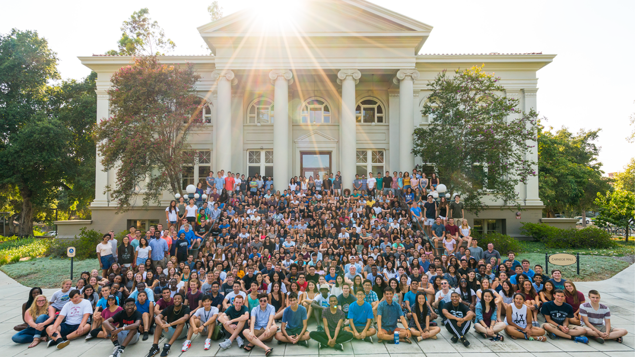 The student class of 2020 sitting in front of the Carnegie building.