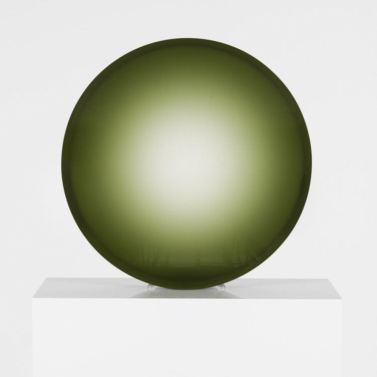 Green disc on white pedestal