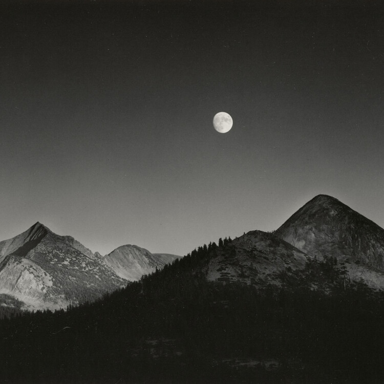 black and white image of mountains and moon