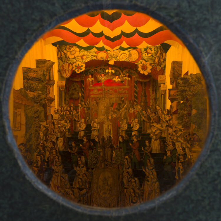circle window into an orangey red scene of people in a room