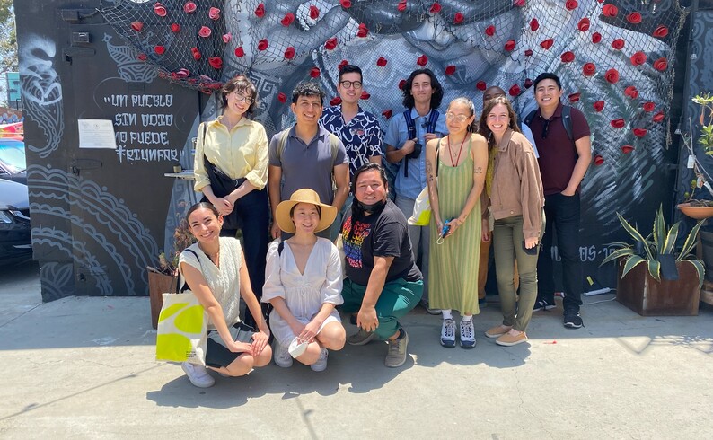 group of people in front of a mural