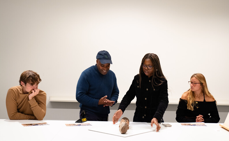Students look at artwork on table