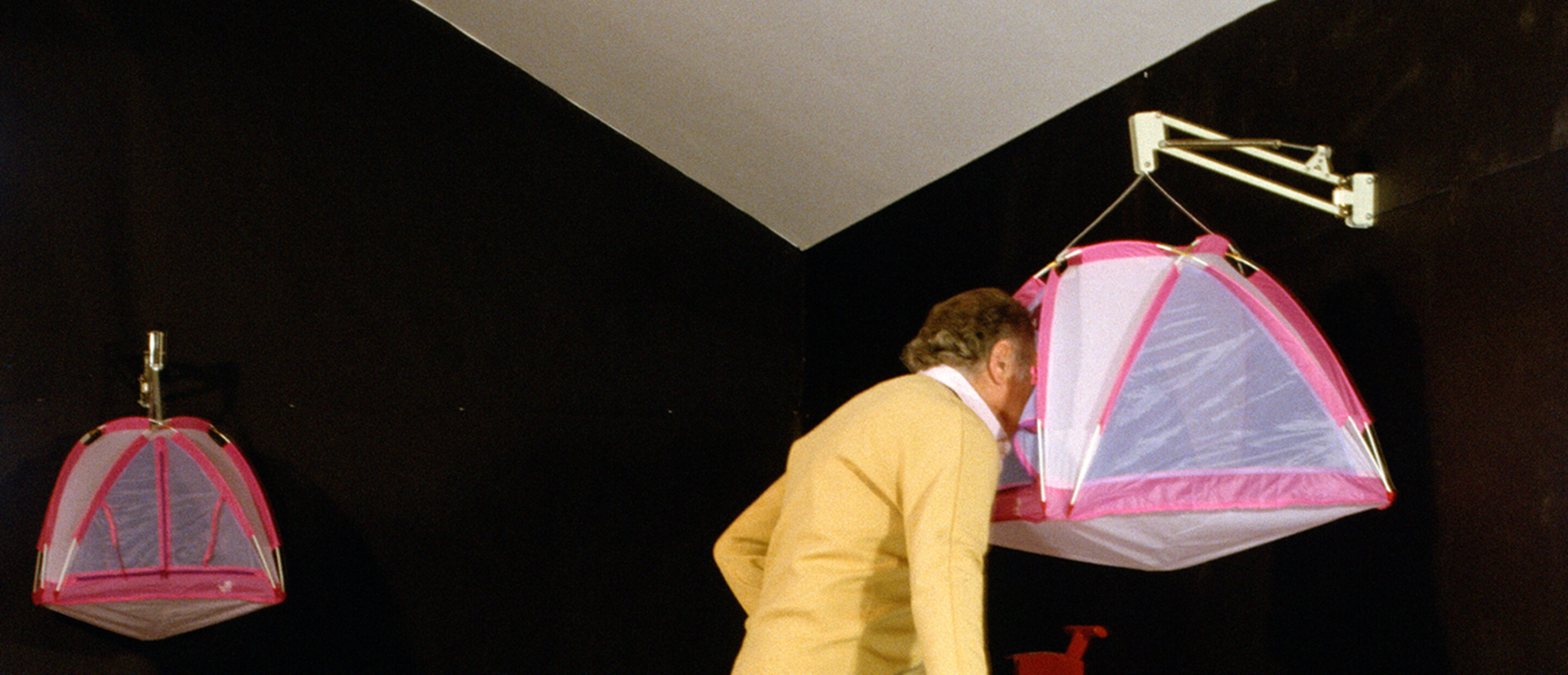 A person looking through a small tent mounted high using a cycle with stairs moving structure