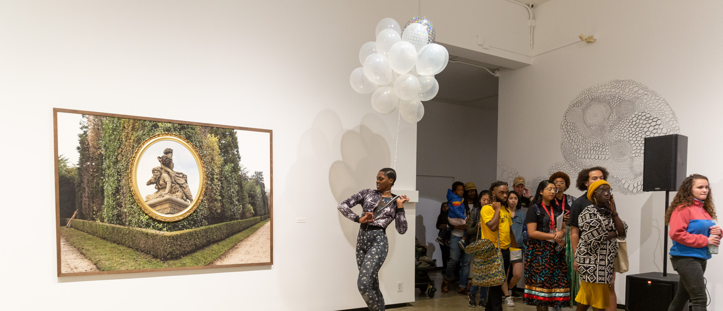 Performance artist entering into a gallery with a group of followers behind