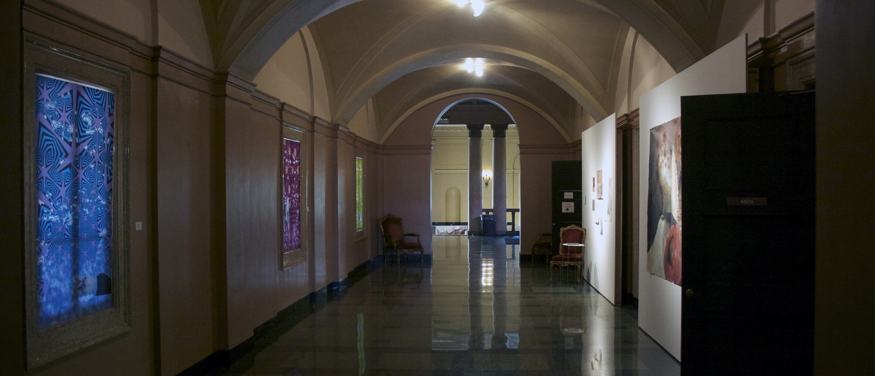 Hallway full of artwork hung on walls and make shift panels