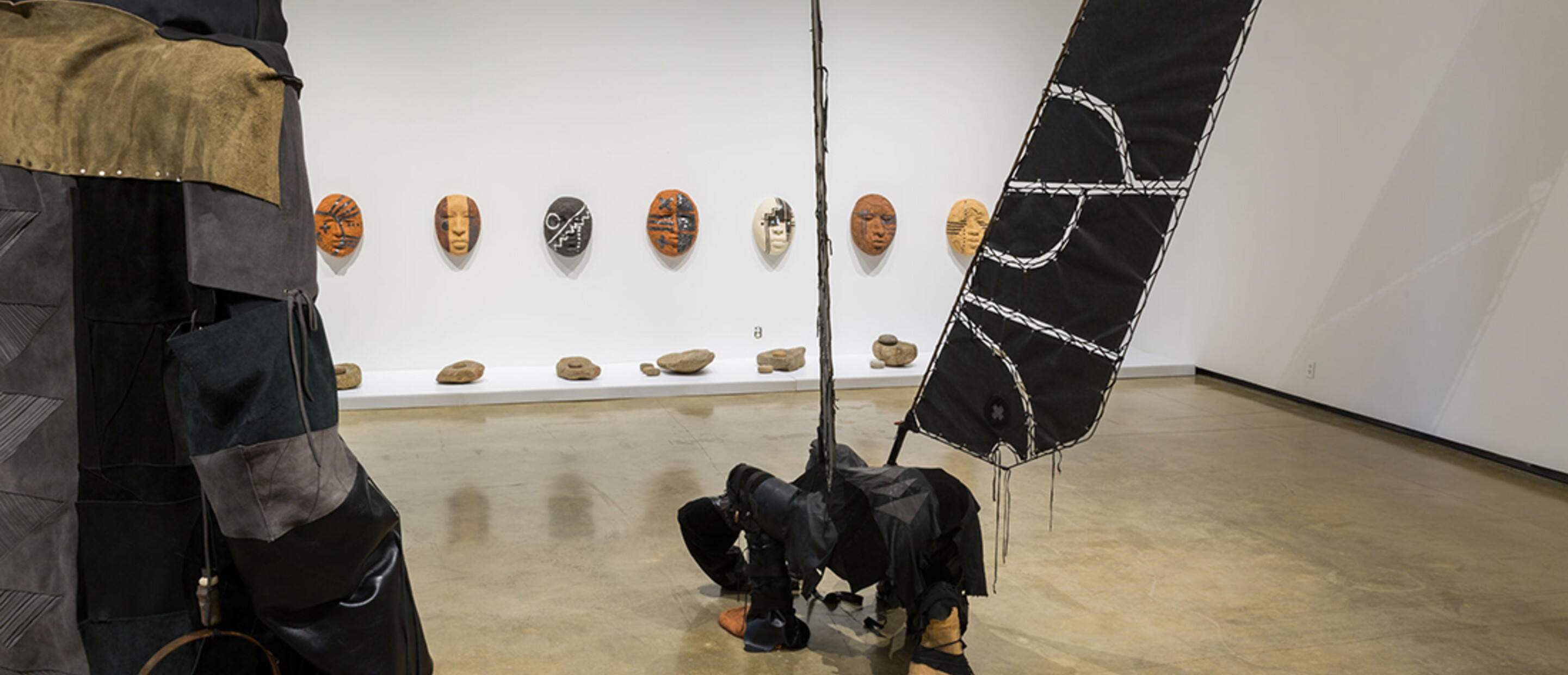 Installation view of sculpture on wall and on floor