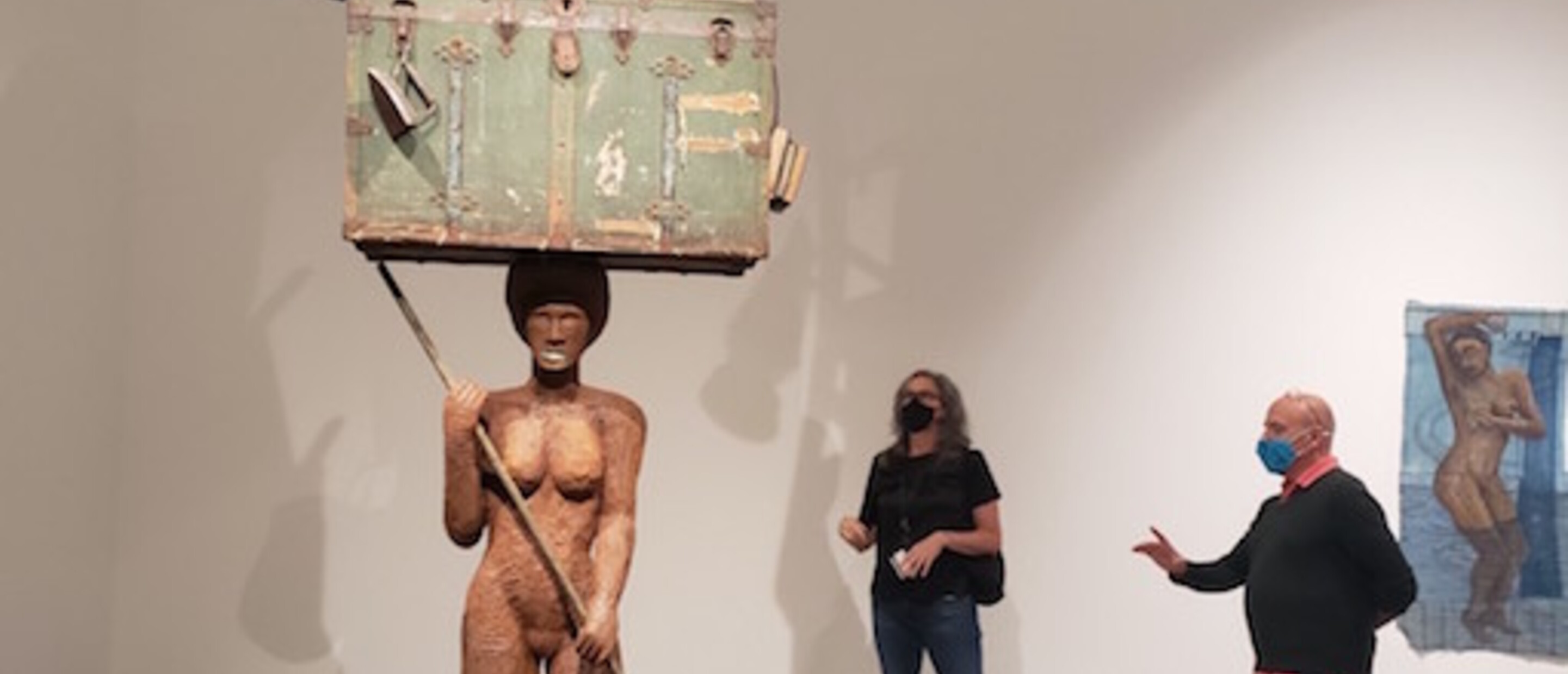 2 people standing with a large sculpture inside a museum gallery