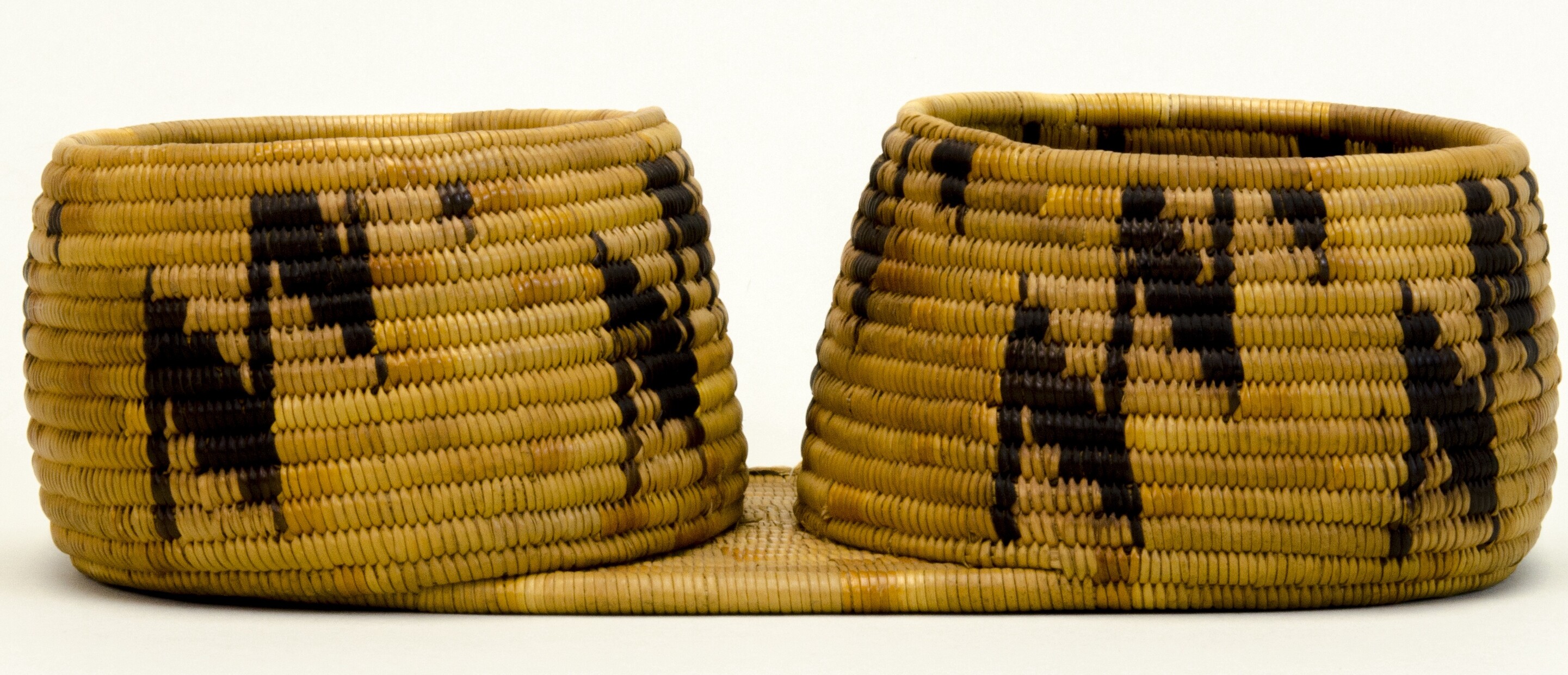 Two restricted hemispherical baskets sharing a common flat base. Coiled construction. Black zigzags on buff.