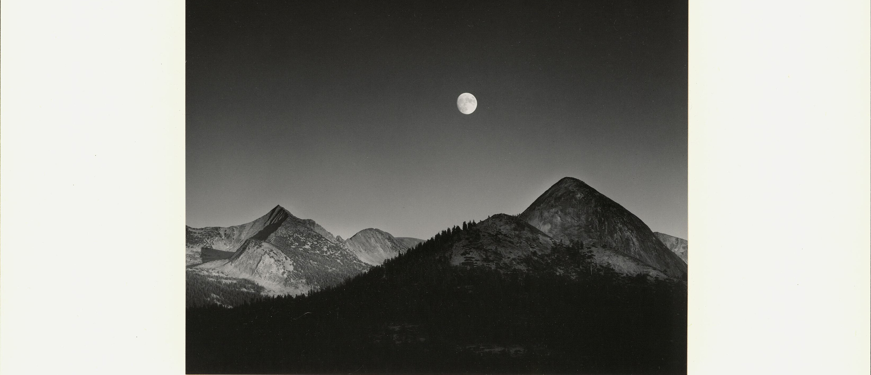 black and white photograph of mountains and moon