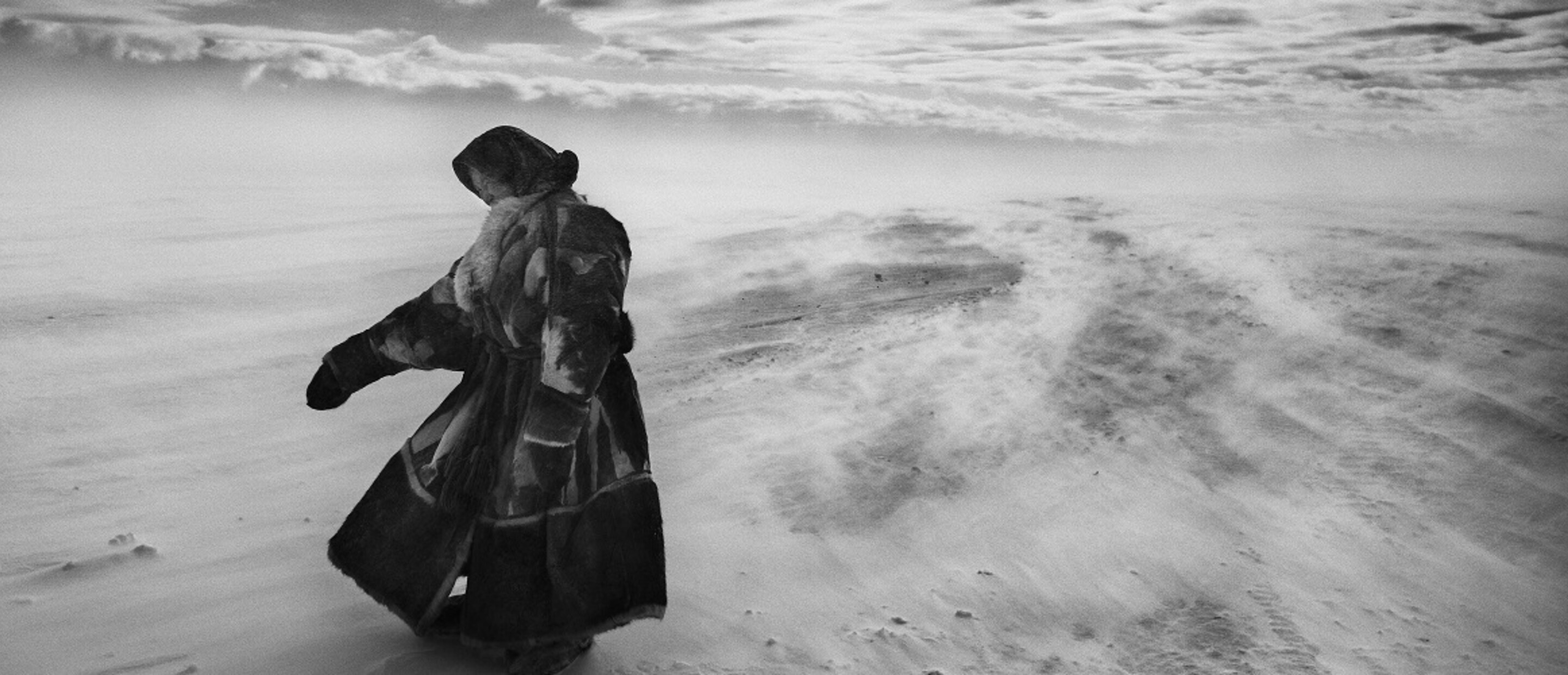 Woman standing in desolate landscape