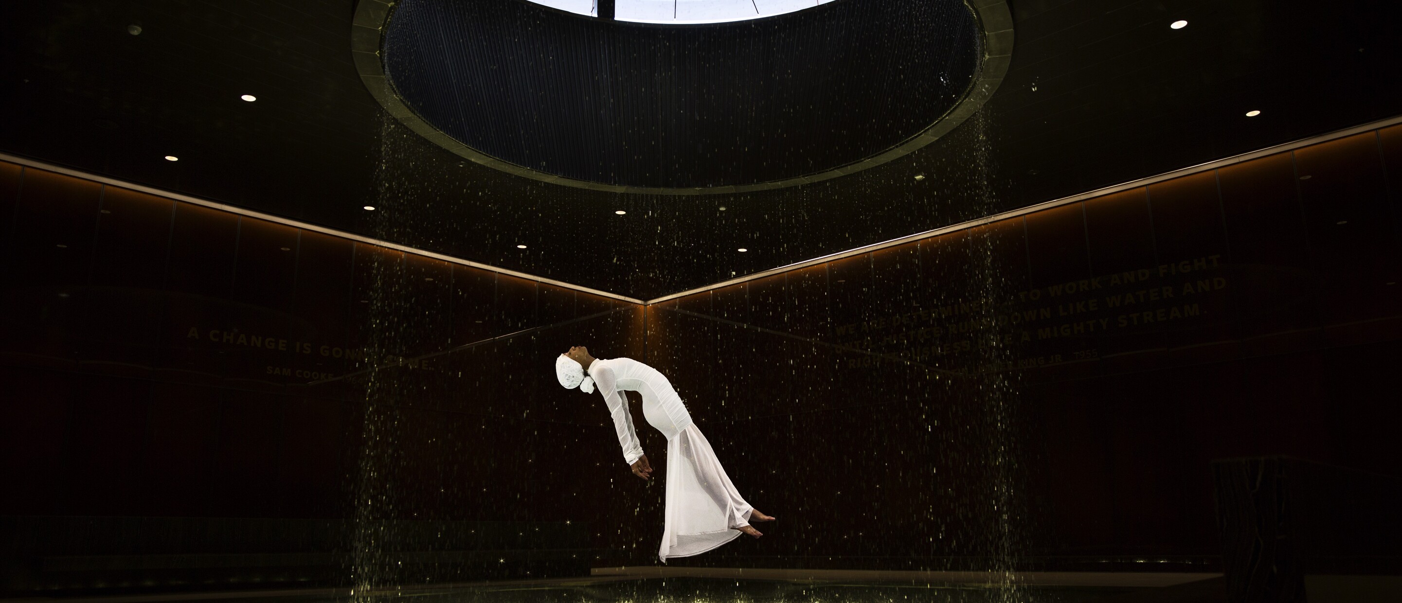 woman in white floating in black room