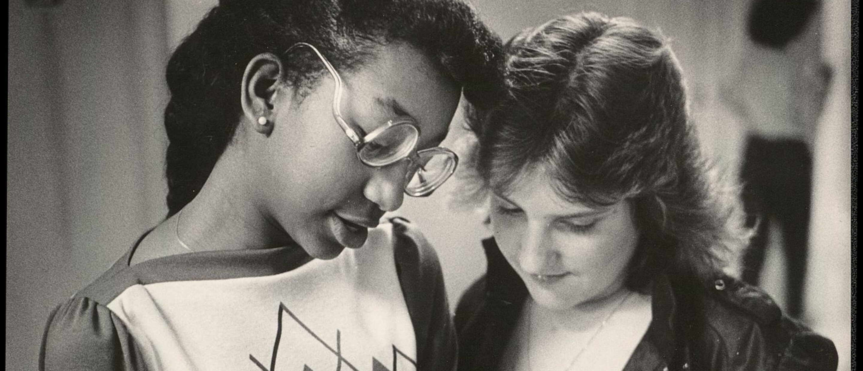 two teen girls writing in book