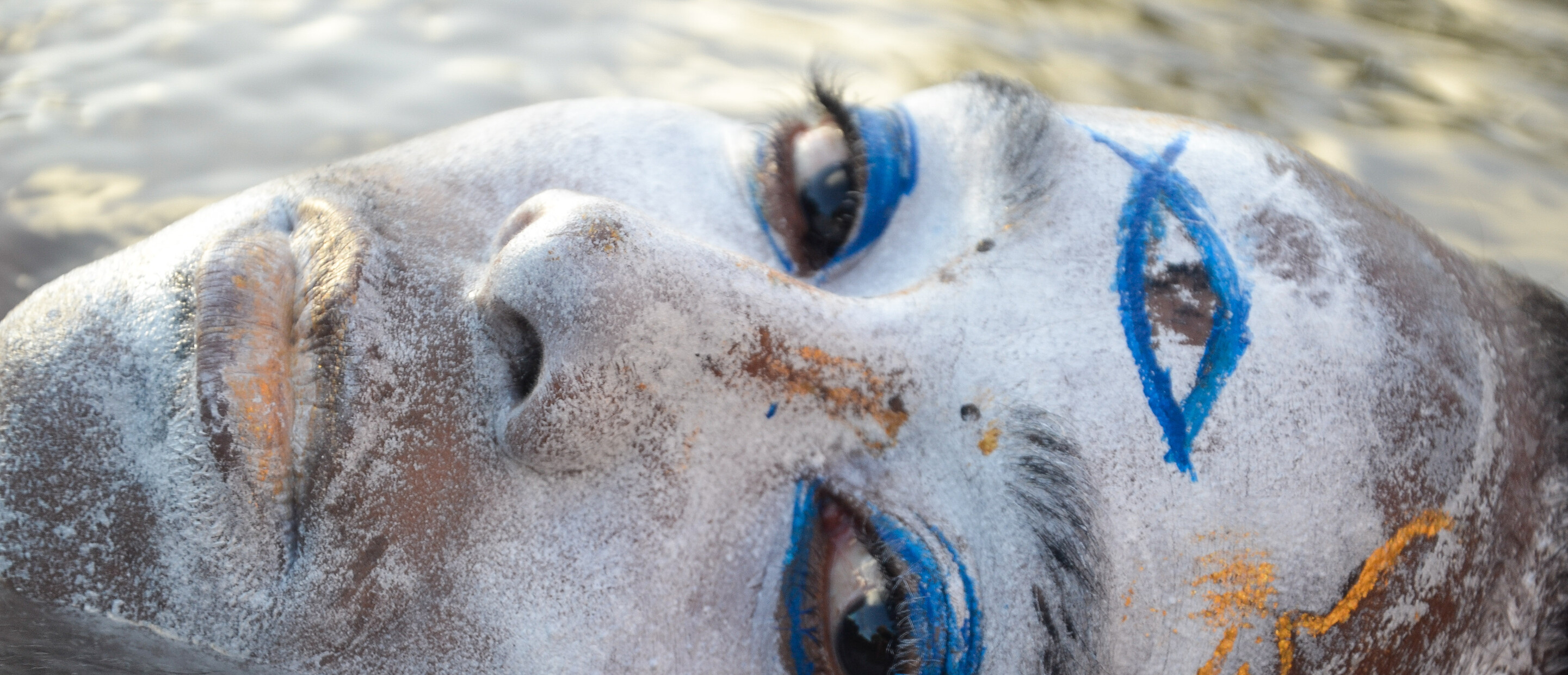 painted 3rd eye on face emerging from water