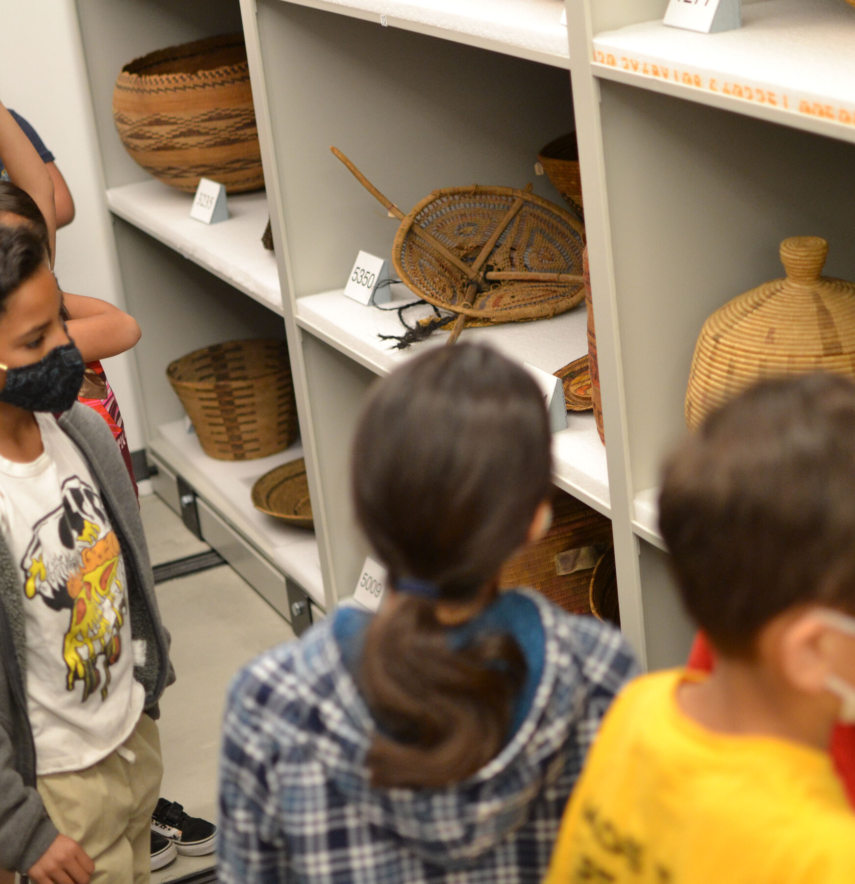 kids in front of native baskets