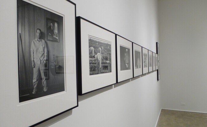 Installation view of a gallery with row of photographs