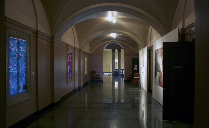Hallway full of artwork hung on walls and make shift panels