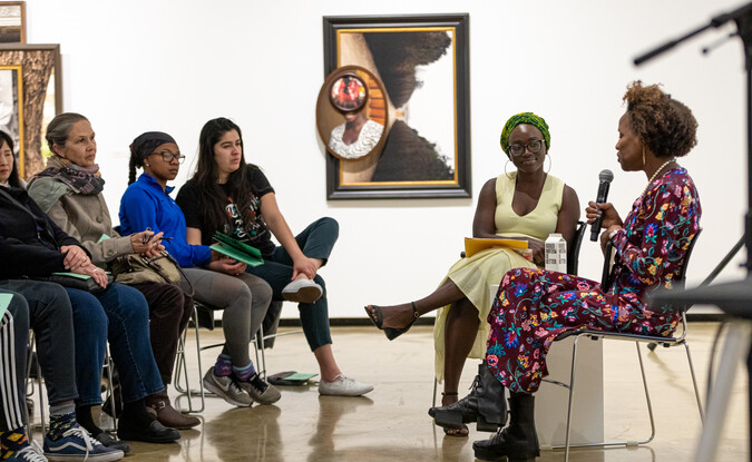 Two people in a panel at the front of a group of audiences 