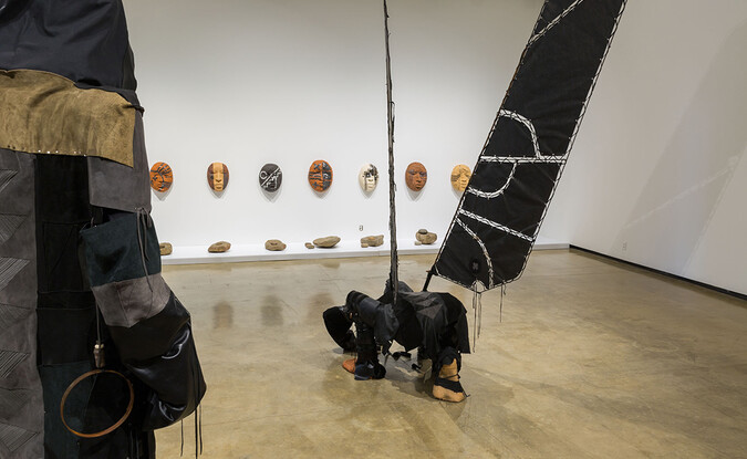Installation view of sculpture on wall and on floor