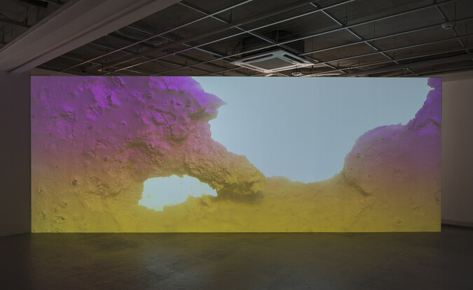 Video installation showing image of geological like landscape in gallery