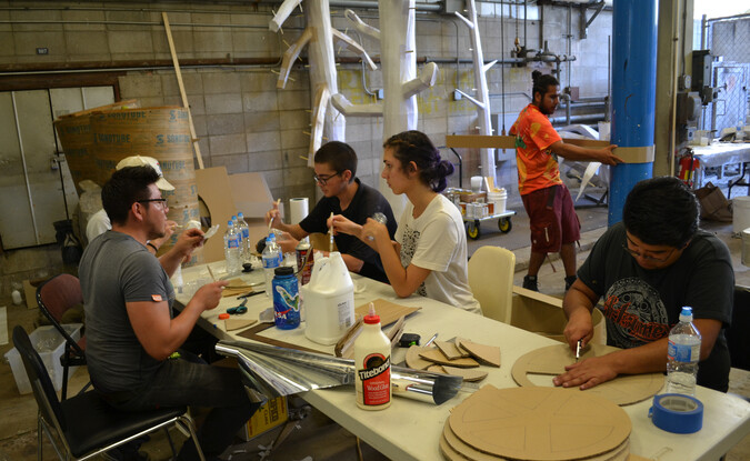 Group photograph with students and the Guerrilla Girls art collective in front of the Pomona College Museum of Art lobby and signage
