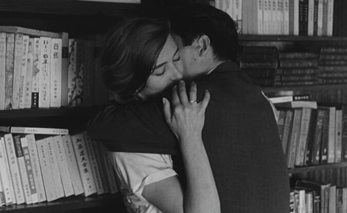man and woman embrace against bookshelf