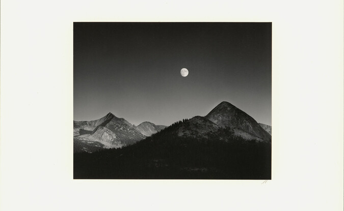 black and white photograph of mountains and moon
