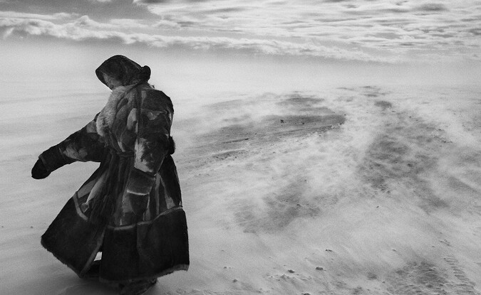 Woman standing in desolate landscape