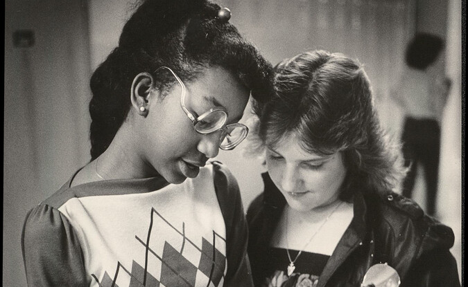 two teen girls writing in book