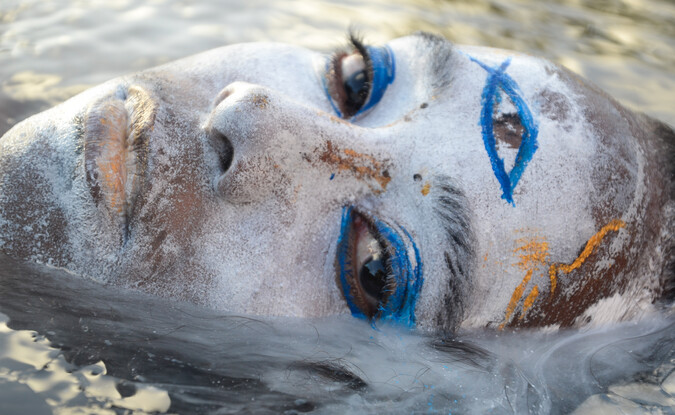 painted 3rd eye on face emerging from water