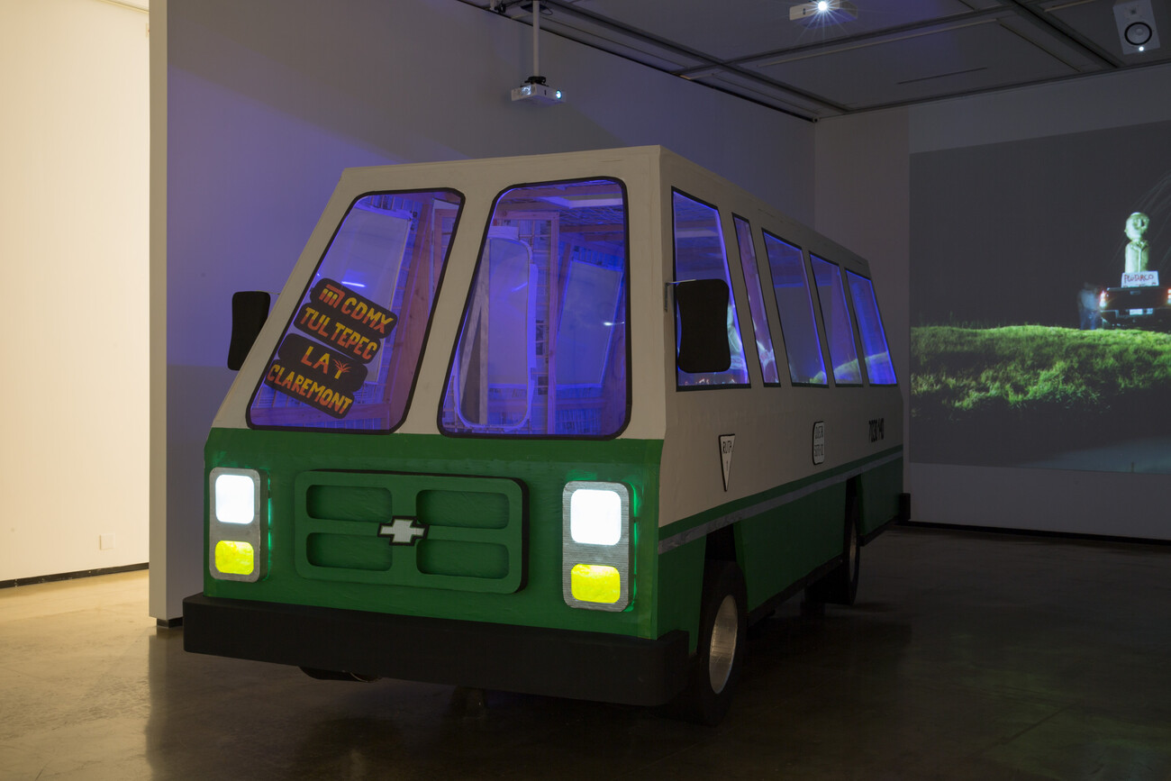 Microbus and cactus in gallery with projection against wall