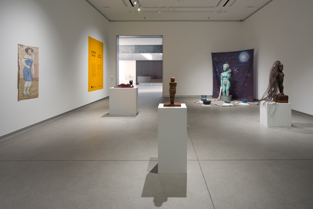Installation view of a gallery exhibition with sculptures on pedestals and 2 dimensional work on walls
