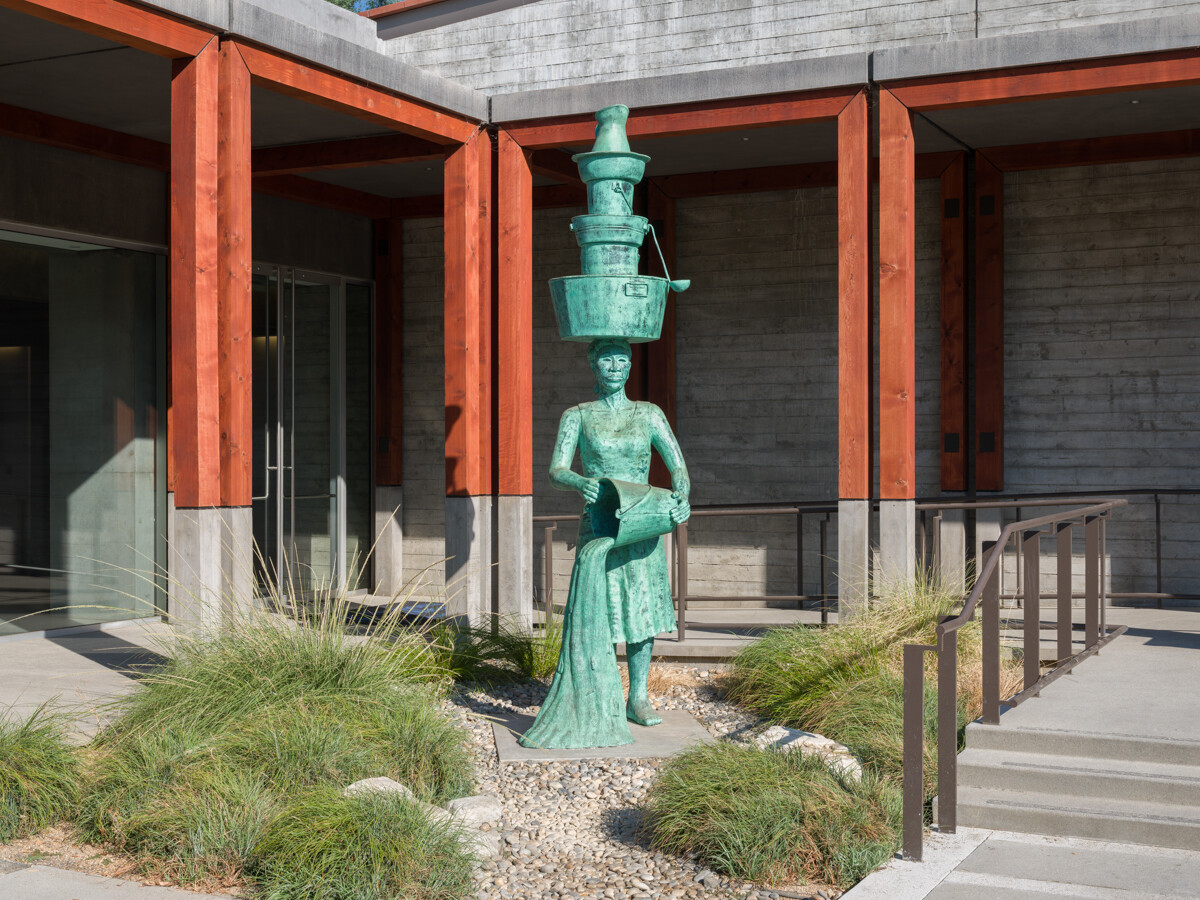 Aqua colored 12 foot bronze sculpture in an open courtyard 