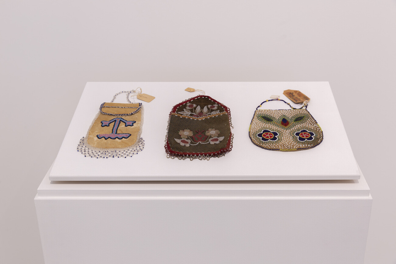 Three pouches with intricate beadwork and details presented in a gallery