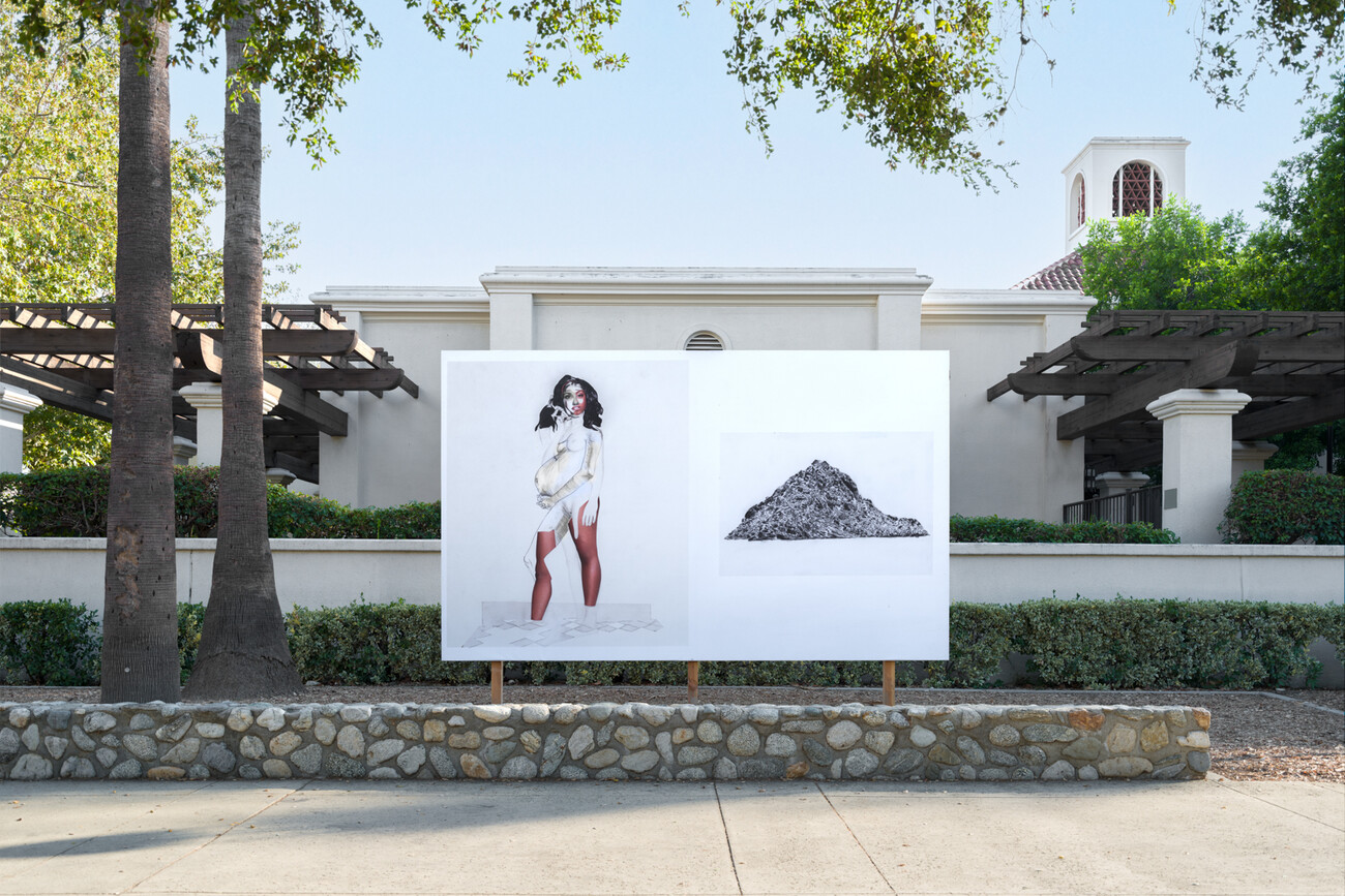 white billboard behind short rock wall, in front of a white building, and two trees
