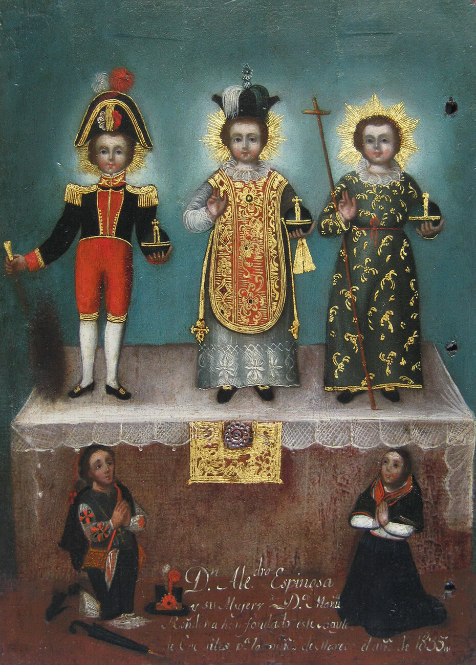 three children on table with different dress. two adults in bottom corners look up at the children
