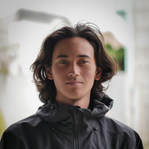 Man with medium wavy hair wearing black rain jacket