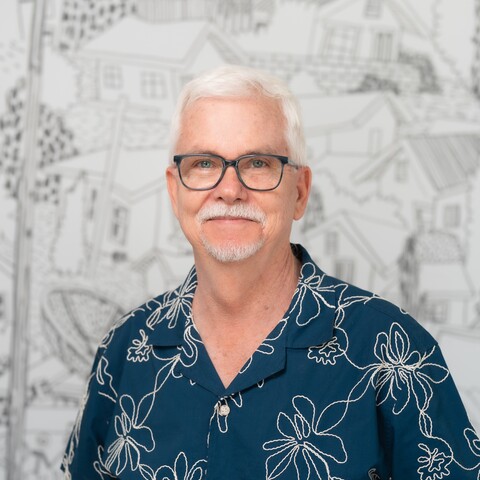 man in glasses smiles at camera