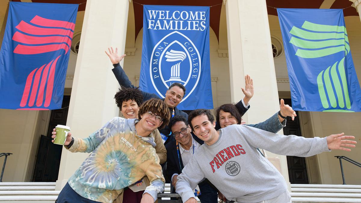 photo of a Pomona College family in front of Bridges Auditorium with a banner behind them that says welcome families