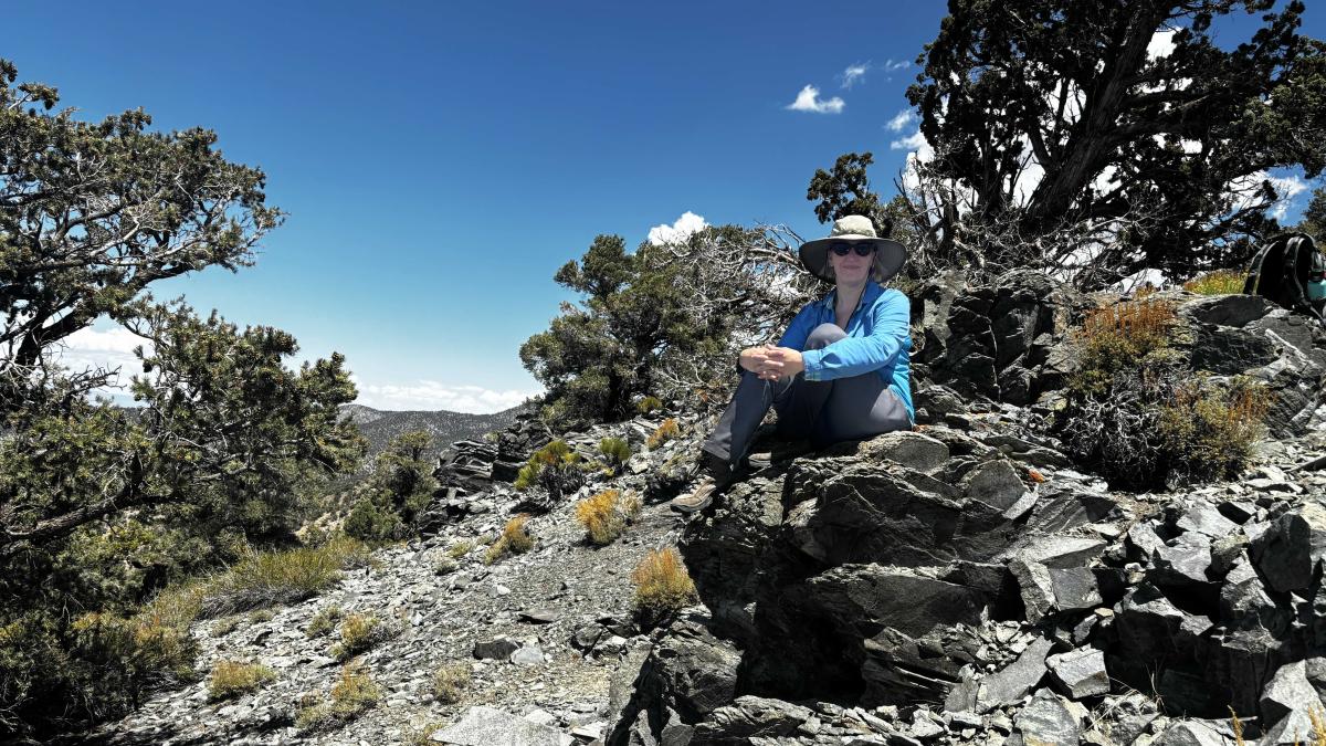 Nikki Moore sits on a pile of large rocks in the Sierra Nevada