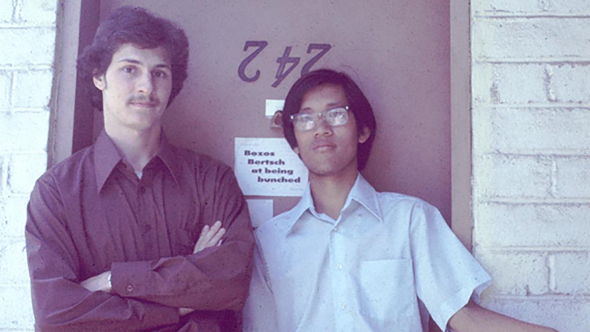 two Pomona students standing in front of a door