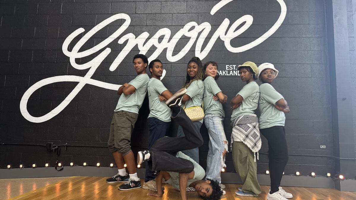 Students pose inside a dance studio