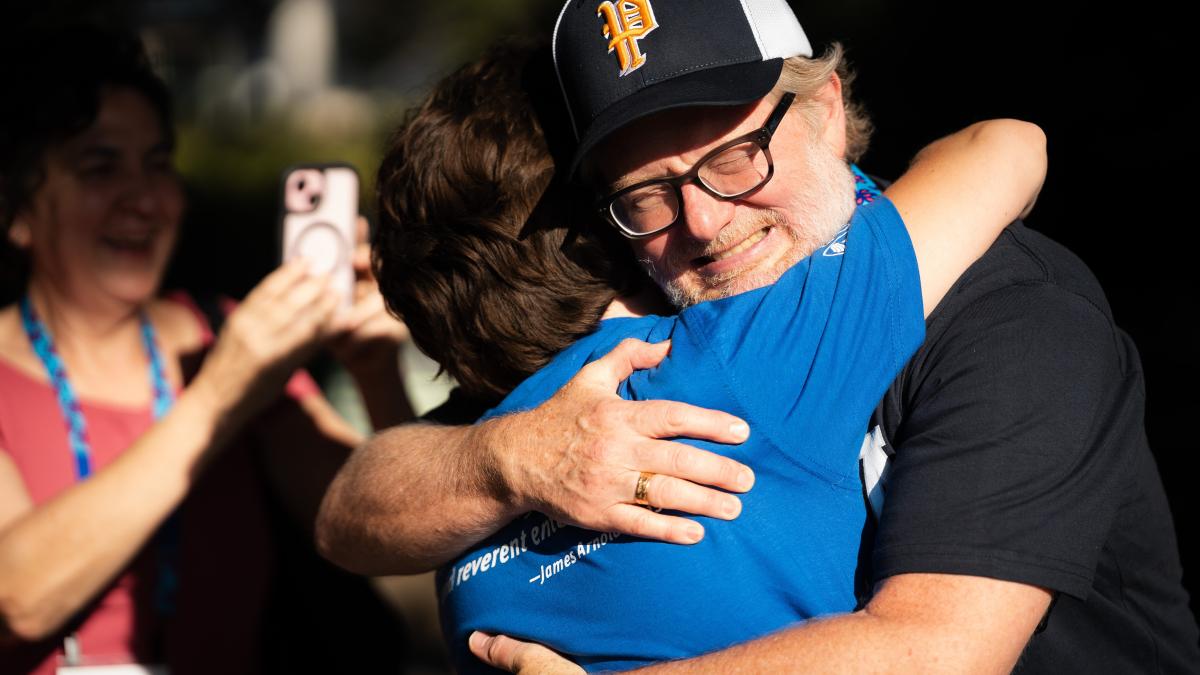 A parent hugs his child goodbye