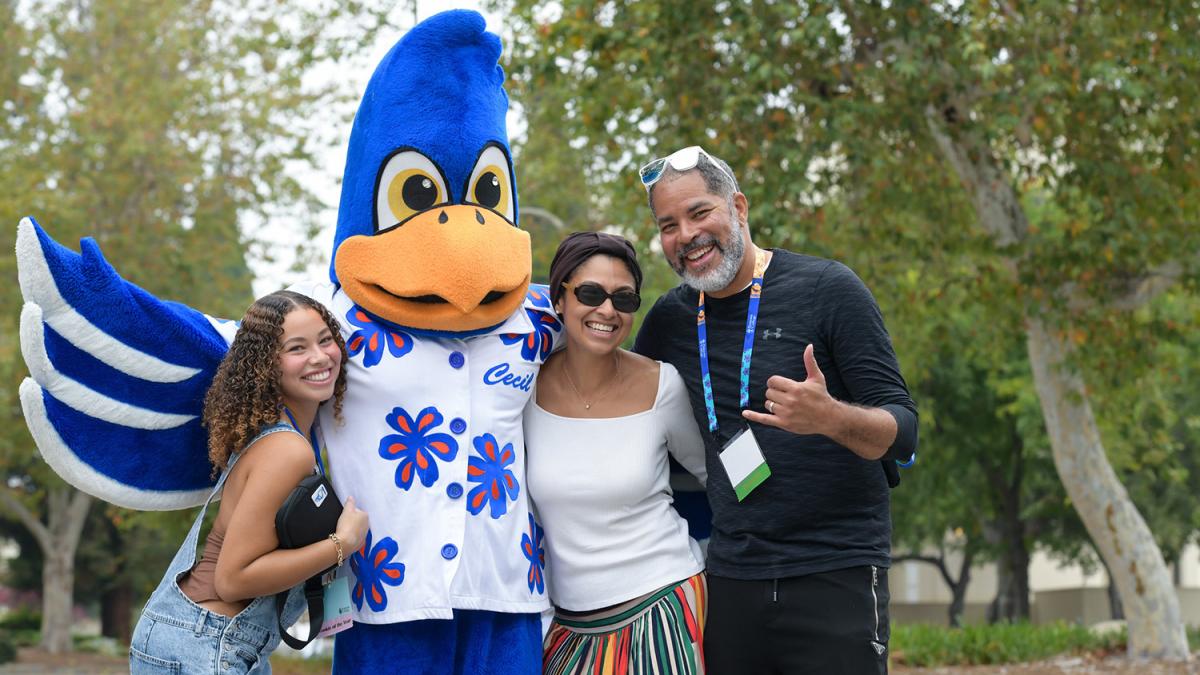 Pomona family with father, mother and daughter posting with Cecil the Sagehen