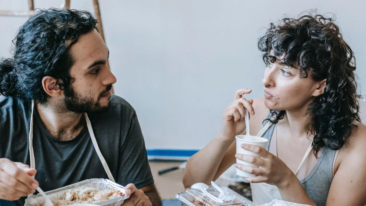 tow individuals eating and looking at each other