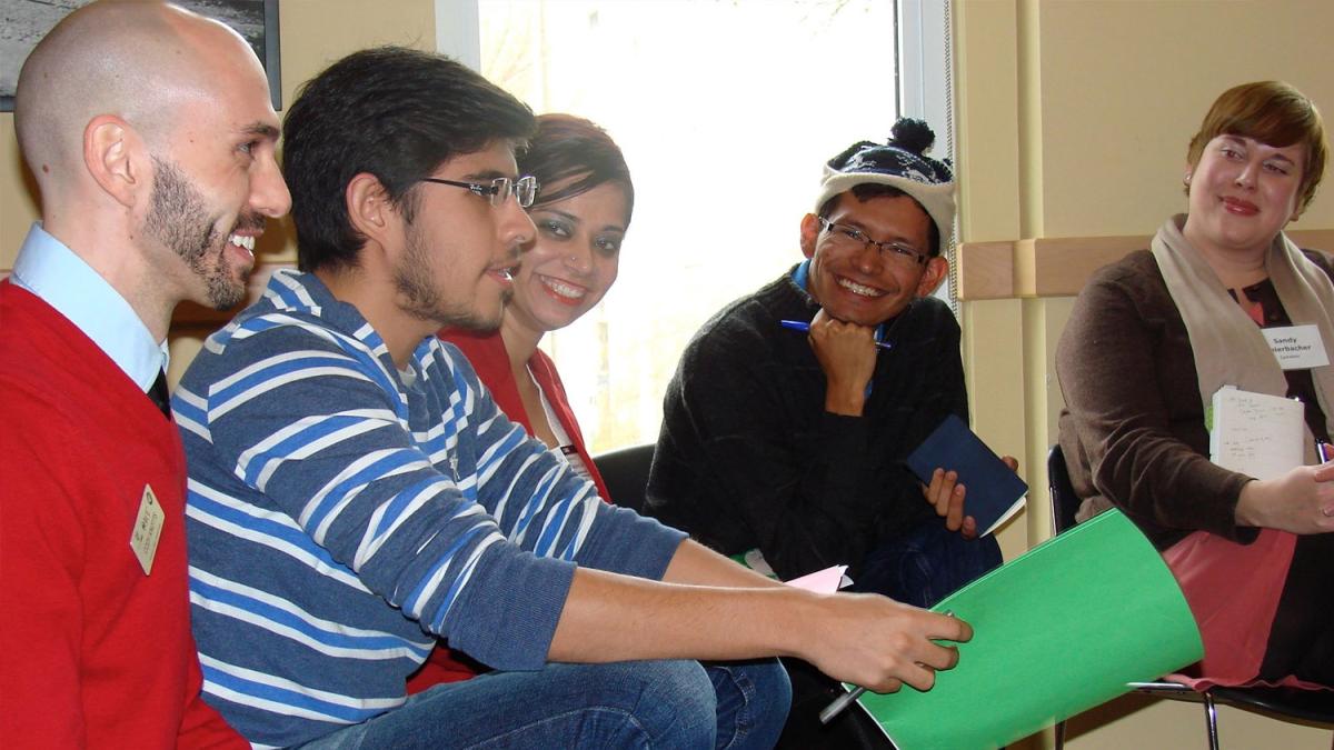 five individuals sitting and smiling