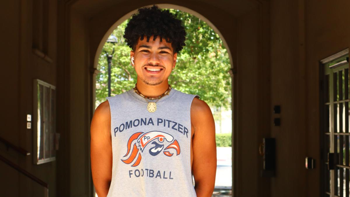 Student posing by arch.